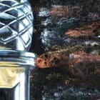 Detail image highlighting the abstract, metallic acrylic pour background.