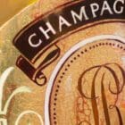 Close-up detail of Monica Marquez Gatica's 'Cristal Elegance,' showing the meticulous oil painting of a Cristal Champagne bottle, emphasizing the reflective surfaces and tactile textures.