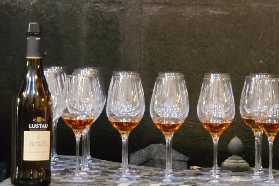 Lustau Fino bottle on the right with a lineup of gleaming wine glasses beside it.