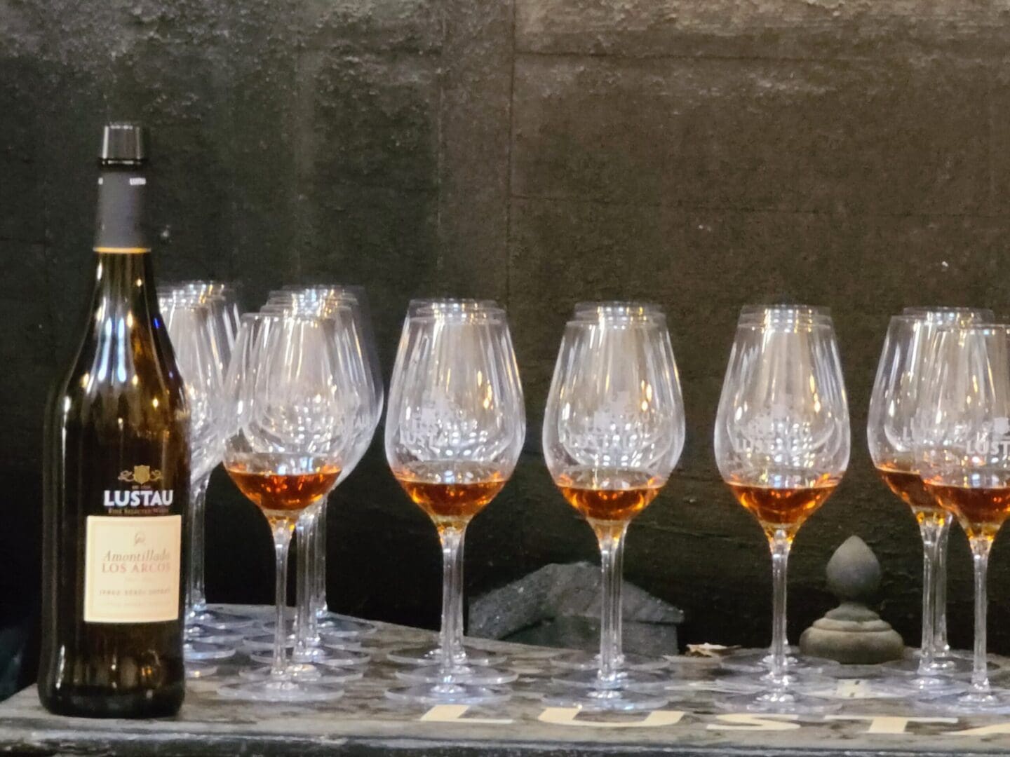 Lustau Fino bottle on the right with a lineup of gleaming wine glasses beside it.