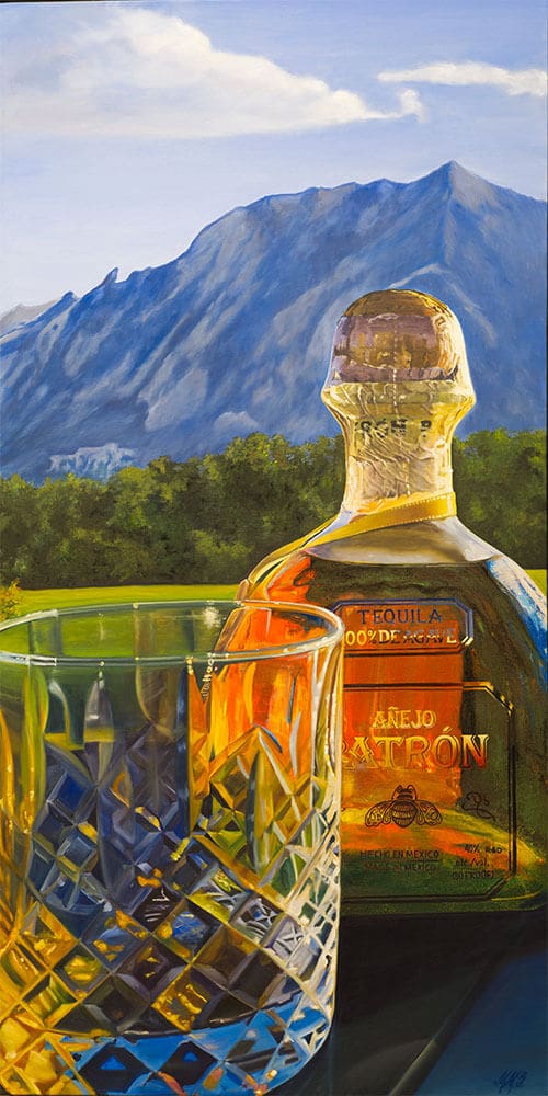 Monica Marquez Gatica's painting depicting a detailed Patron Añejo tequila bottle next to a crystal glass with the Flat Iron mountains in the background.