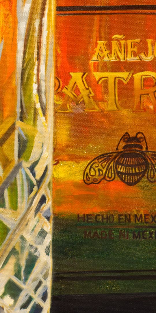 Monica Marquez Gatica's painting depicting a detailed Patron Añejo tequila bottle next to a crystal glass with the Flat Iron mountains in the background.