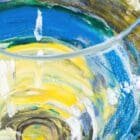 Detail of acrylic pour technique in a wine glass from a hybrid fluid realism painting.