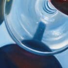 Artistic detail of a shadow cast by a wine glass in a fluid realism painting.